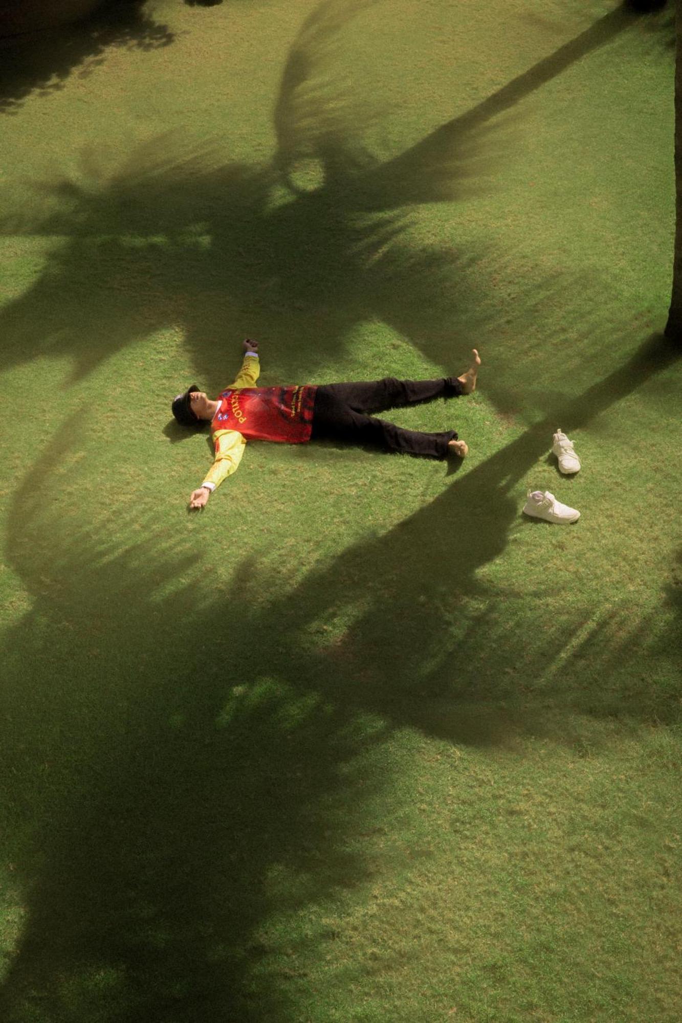 Potato Head Suites&Studios Seminyak Esterno foto A man lying on the grass